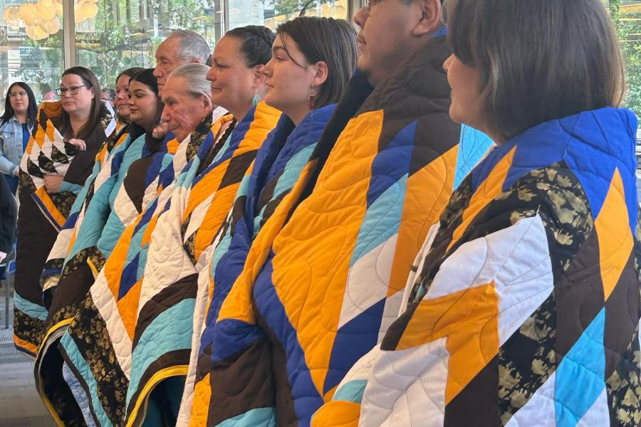 Side photo of award recipients of HOICC wearing their blankets