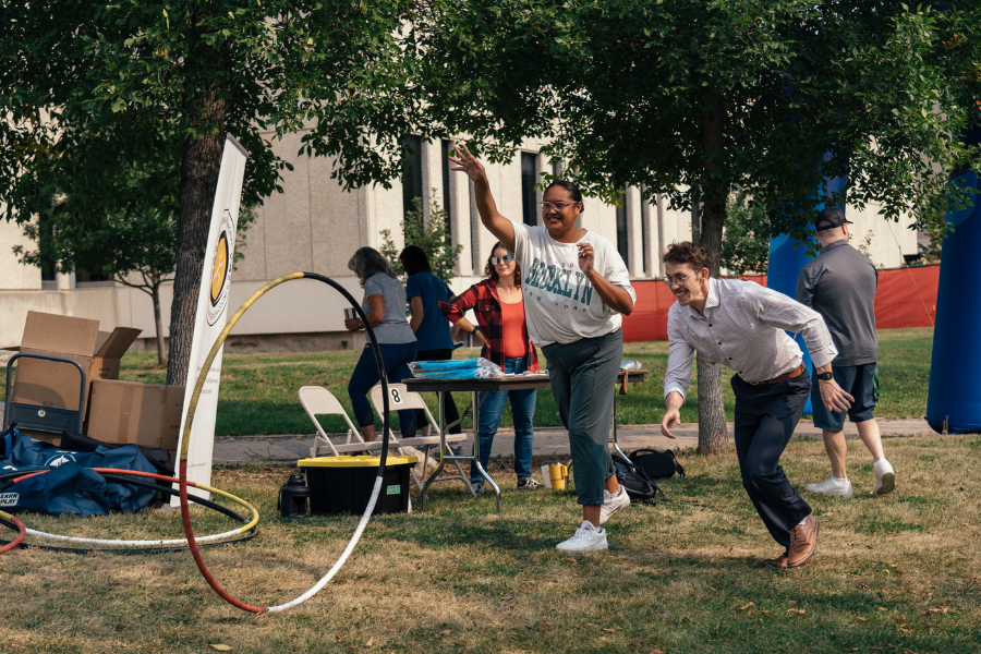 Participants play an outdoor ring toss traditional game.