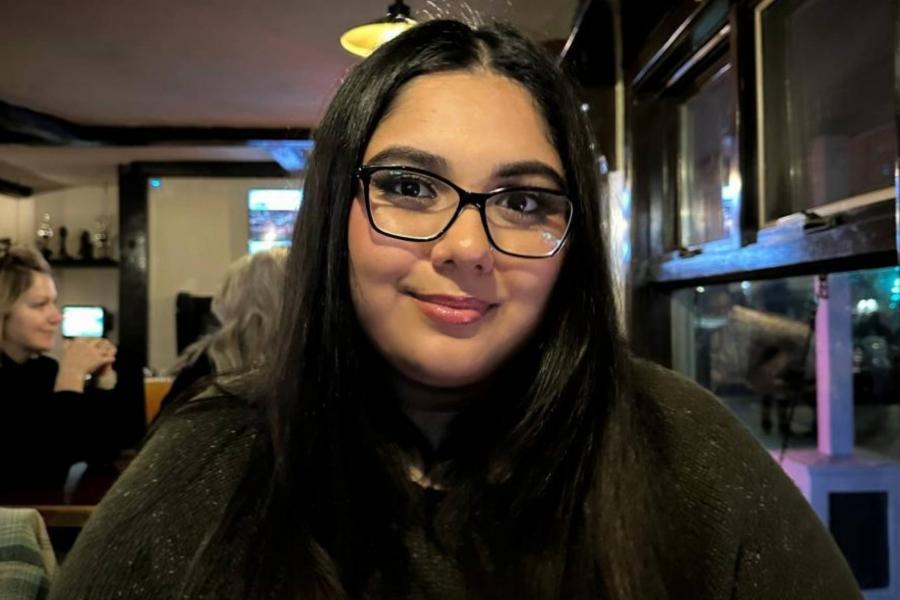 Ishkode Catcheway poses for camera. She has dark hair, glasses and is wearing a black shirt.