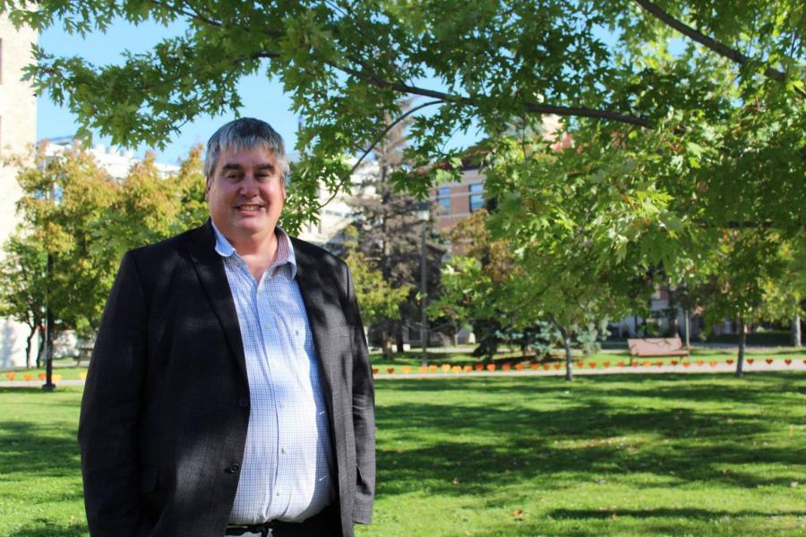 A person standing outdoors on the University of Manitoba campus.