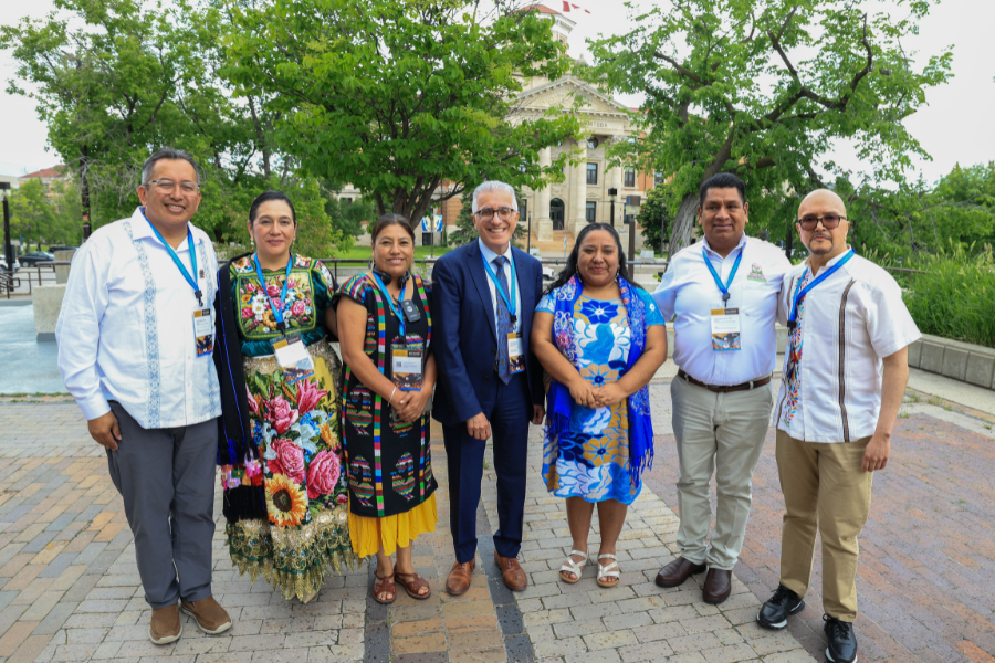 Delegates from Canada and Mexico pose for a group photo outdoors.