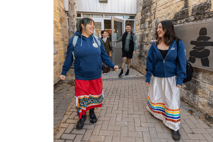 Indigenous students walking together outside Migizii Agamik.