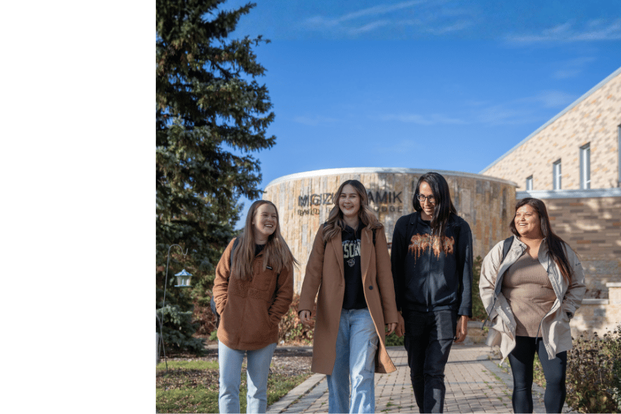 Four Indigenous students walking together on the University of Manitoba campus.
