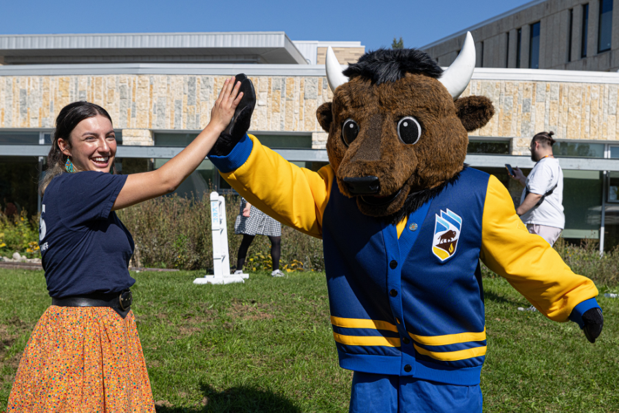 A student high-fiving the UM Bisons mascot.