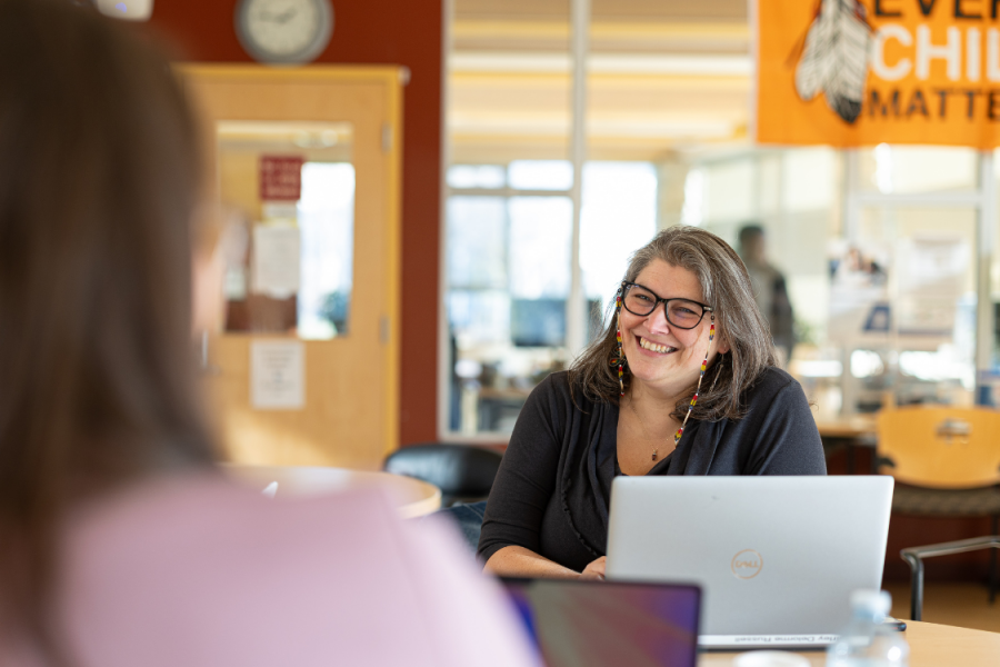 Two participants engaged in conversation during a program gathering.