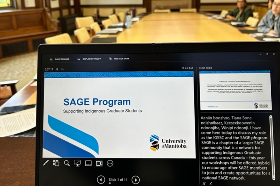 Presentation about the SAGE Program displayed on a laptop during a meeting.