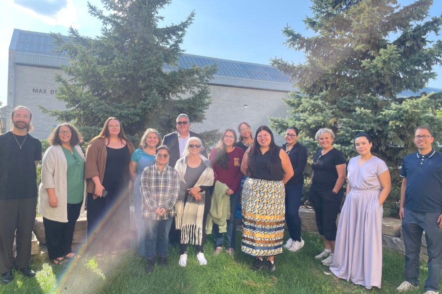 Group of participants gathered outdoors on campus.