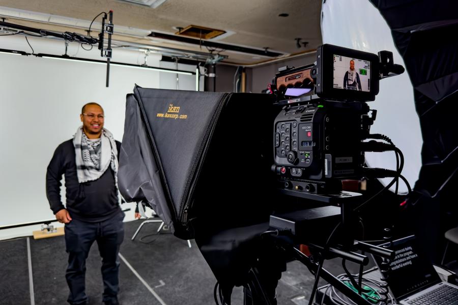 Man standing in front of a video camera in a production studio
