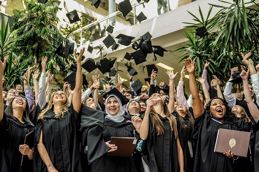 New grads happily throwing their grad caps in the air.