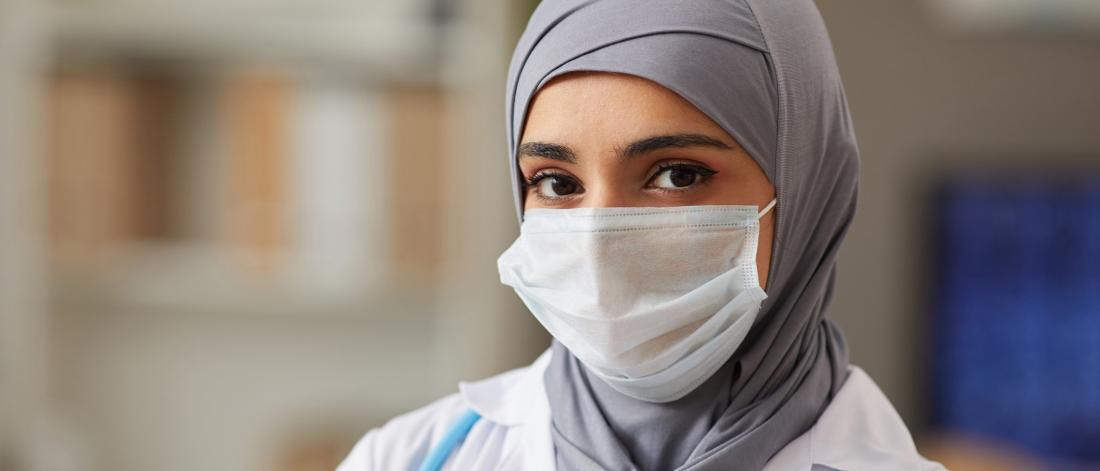 Woman in a head scarf and mask.