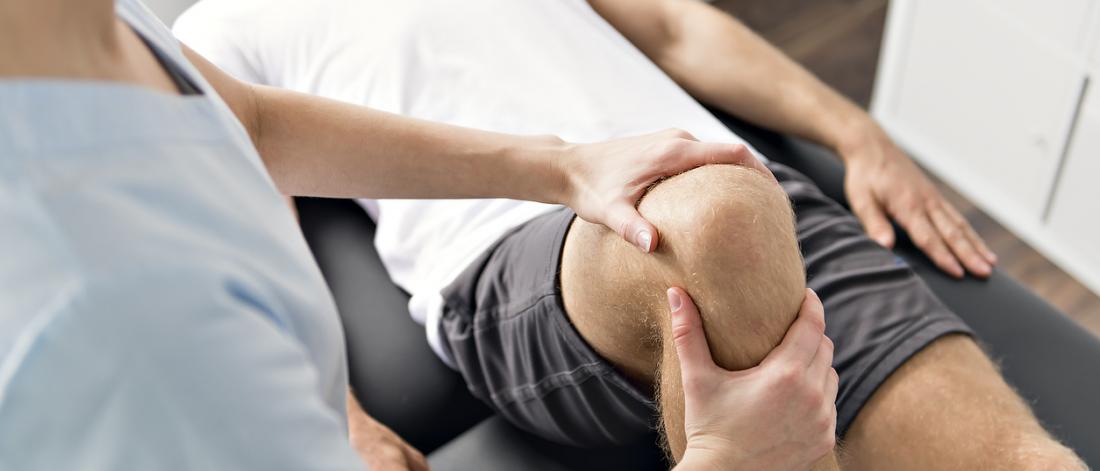 Physiotherapist works on a patient's knee.