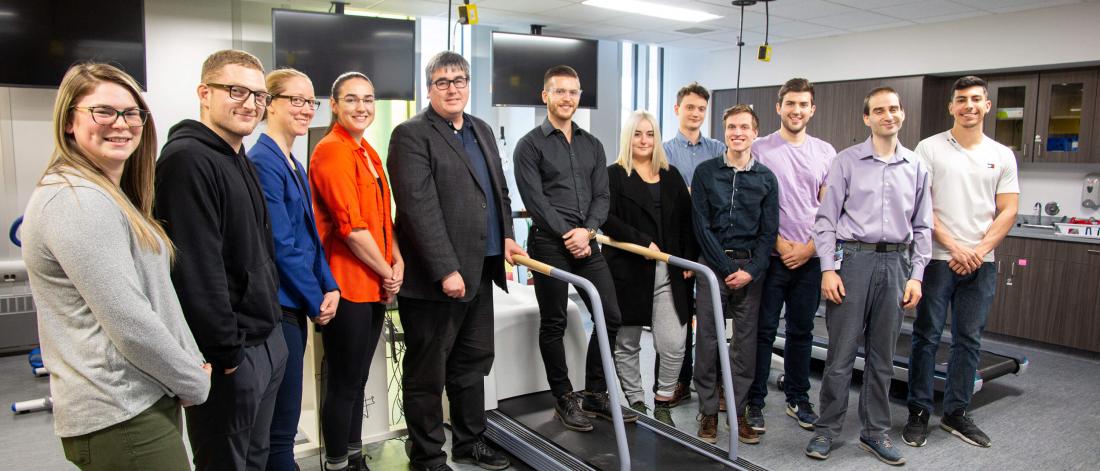 A group of researchers and graduate students stand together in the lab.