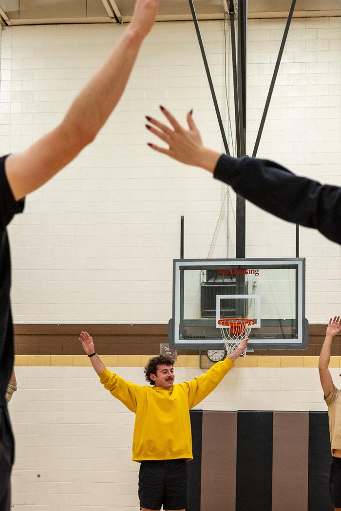 Students doing a group stretch in a gymnasium