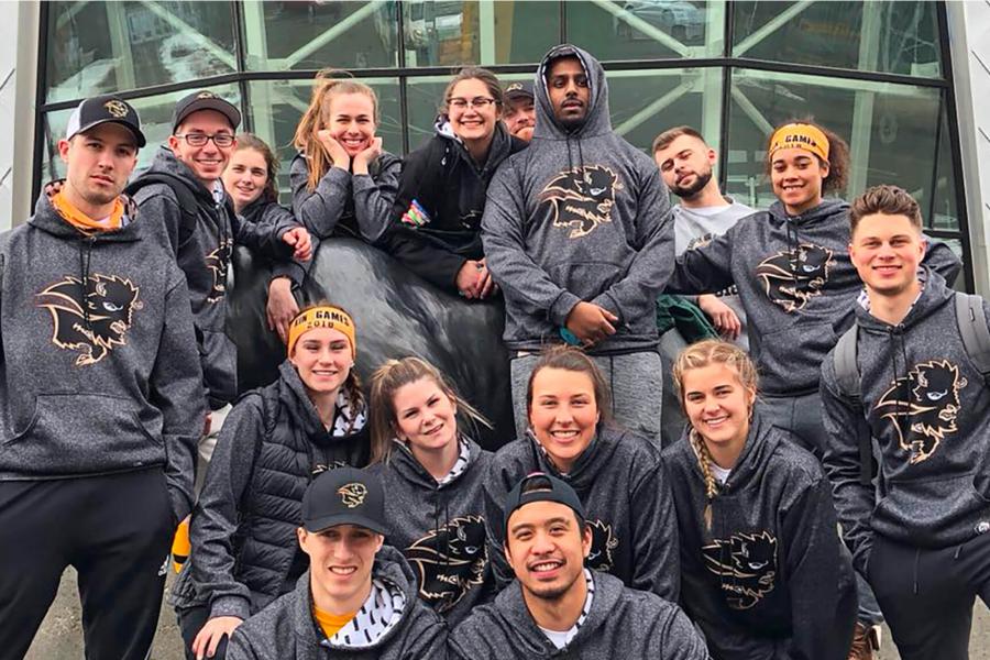 A large group of kinesiology students huddle together to pose for a photo.