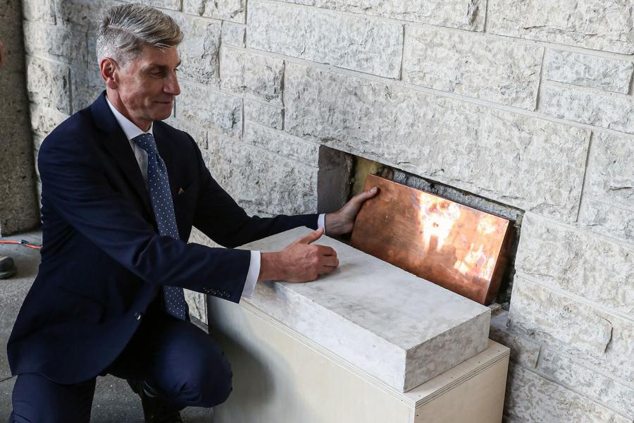 The dean of law replaces the time capsule in the wall
