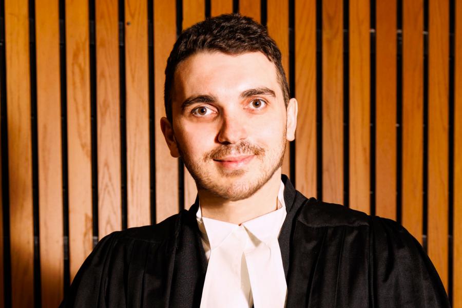 Research Associate Dr. Rokoshnyi wearing legal attire in the Moot Courtroom.