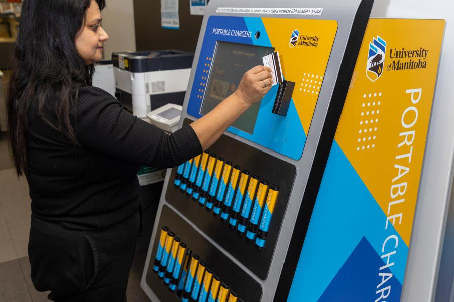 A student using a kiosk full of portable chargers