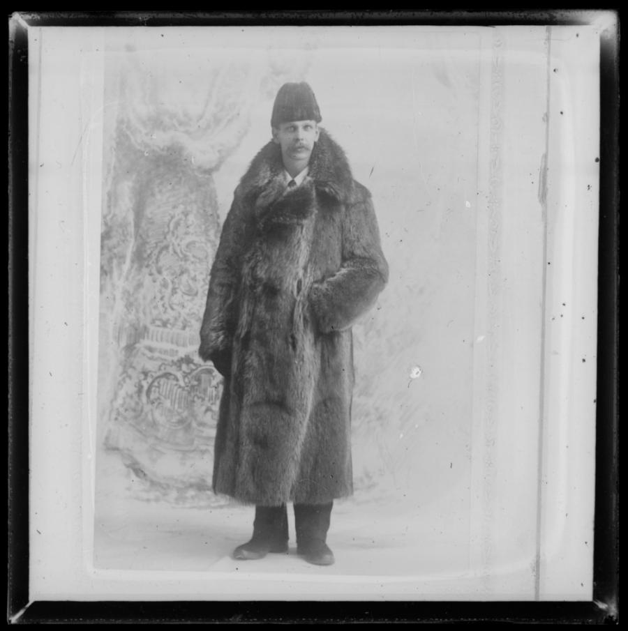 Professor AHR Buller posing for a portait wearing a raccoon fur coat.