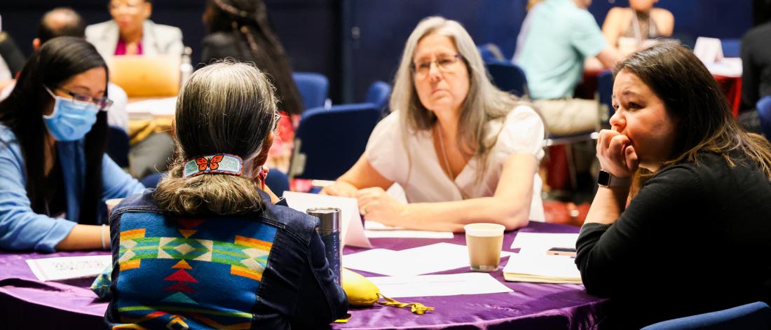 People at a SPECTRUM workshop sitting around a table listening intently to Know