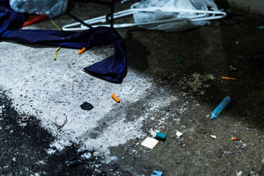 Garbage cluttered alleyway with used syringes and other substance use related items