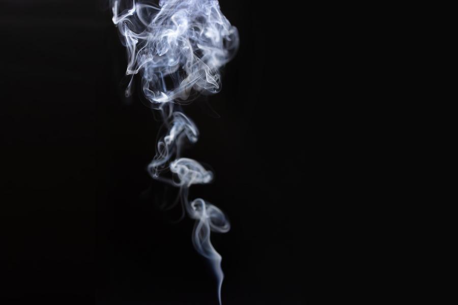 white smoke curling and drifting on black background 