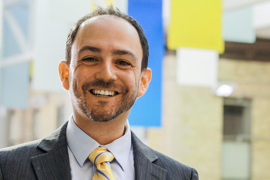 Dr. Nathan Nickel smiling in a brightly lit atrium