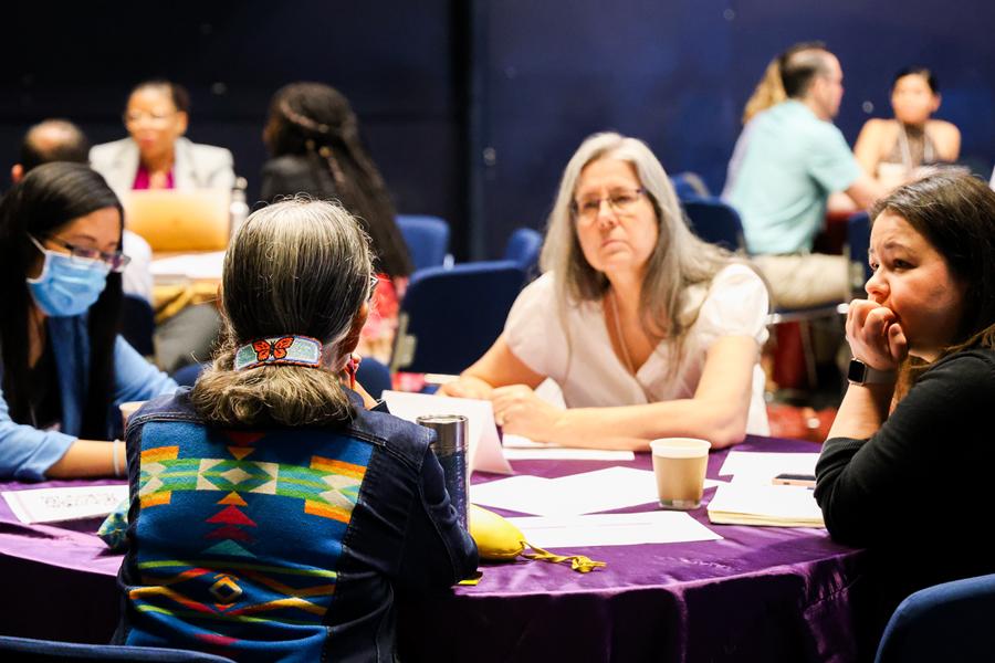 People at a SPECTRUM workshop sitting around a table listening intently to Know