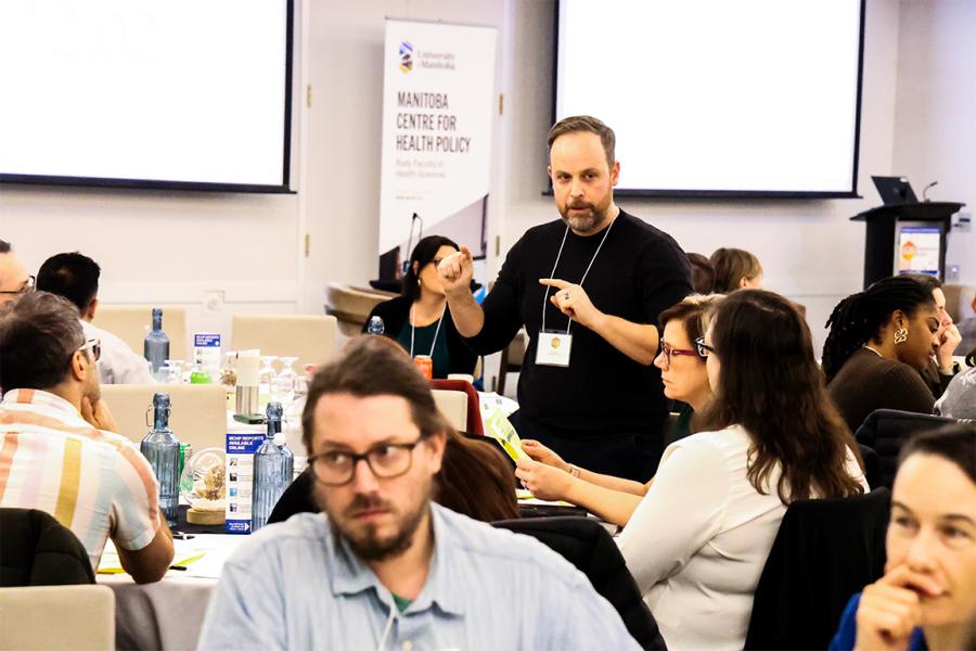 Conference room full of people discussing a topic in a breakout session 