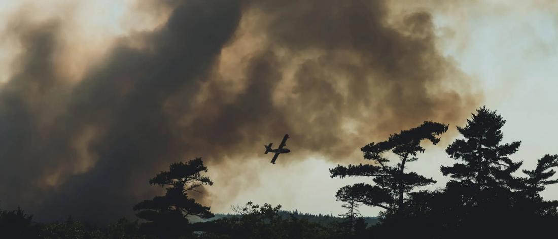 image of plane over smoke-filled skies