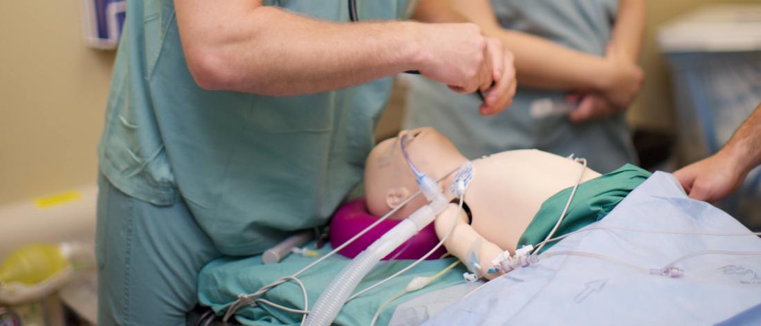 A closeup of a pediatric anesthesia simulation mannequin on a table.