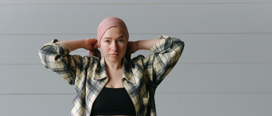 Young woman ties on a head scarf.
