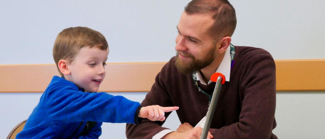 A clinical health psychology faculty member works with a child patient.