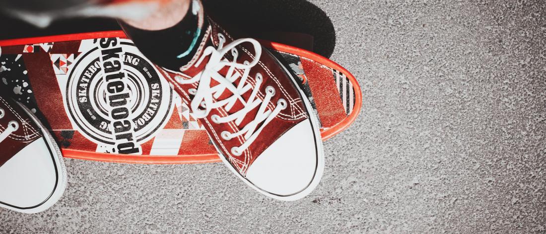 Close up of a boy's shoes as he is skateboarding.