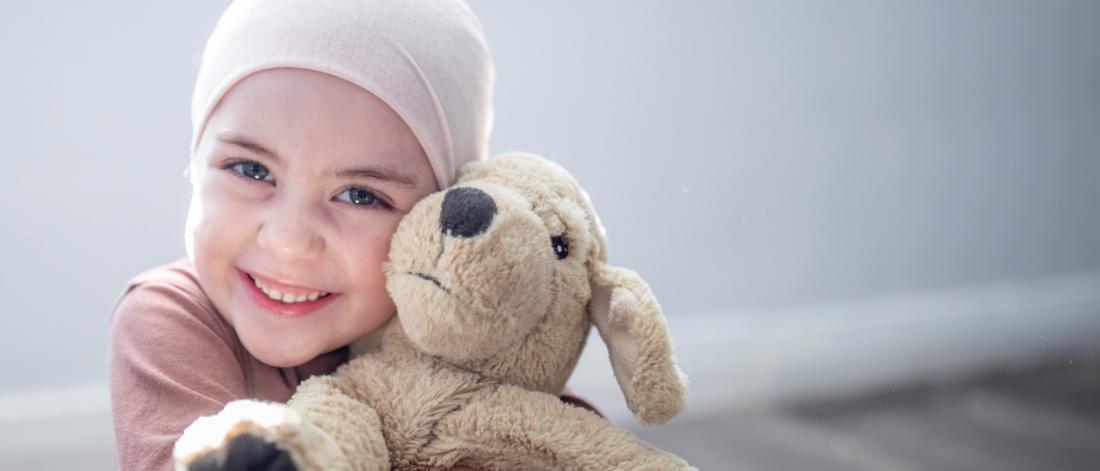 Little girl hugging a teddy bear.