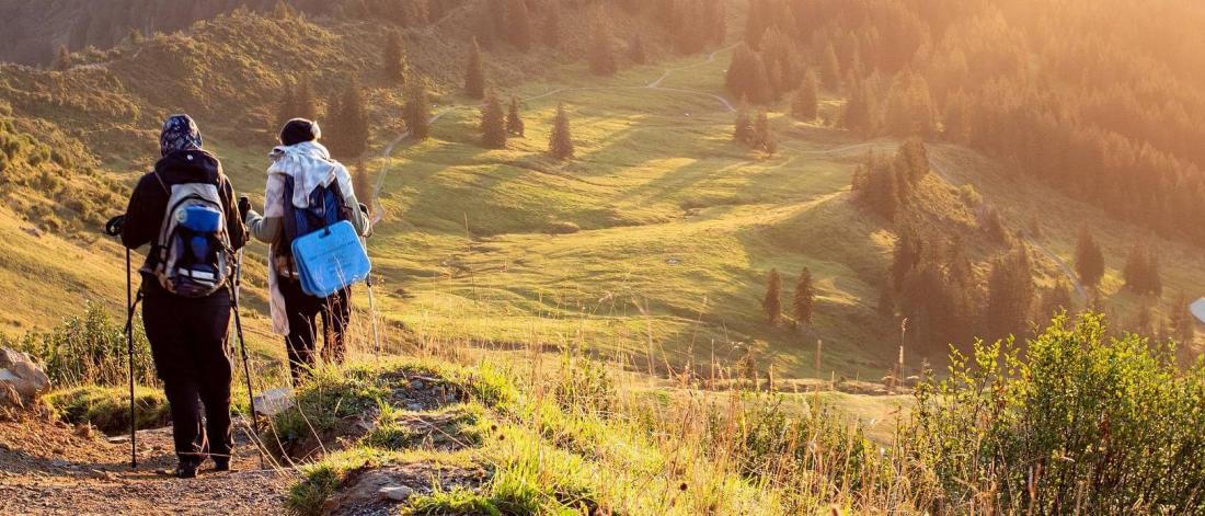 A couple hiking in a beautiful green valley.