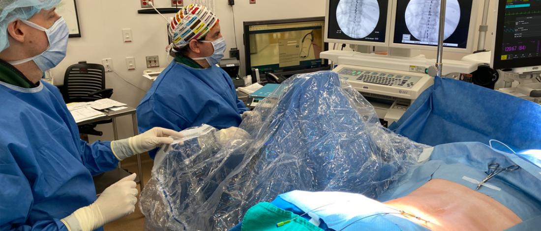 A pair of doctors in surgery, looking at monitors.