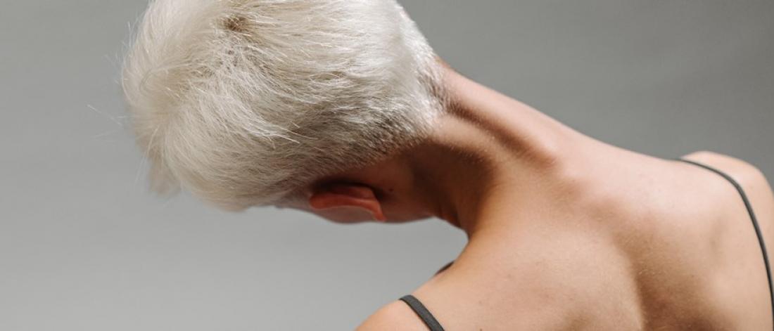 A woman's head and shoulders, head tilted to the left.