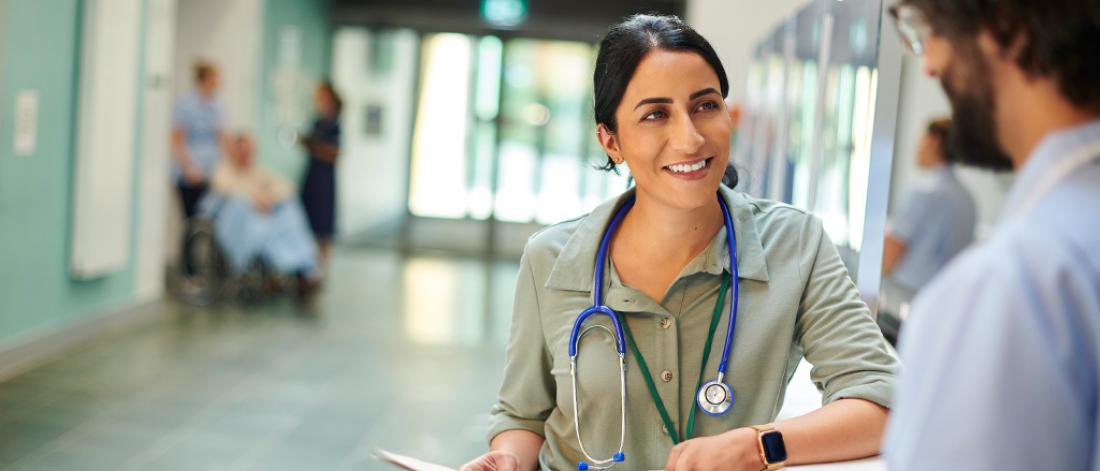 hospital doctor chatting to male nurse in hospital foyer