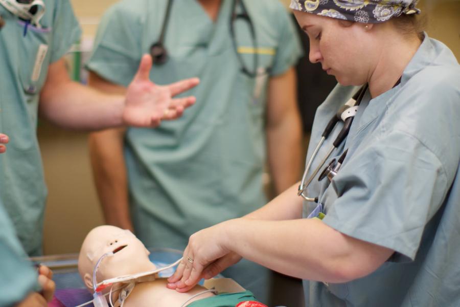 An anesthesiology student works with a simulation mannequin.