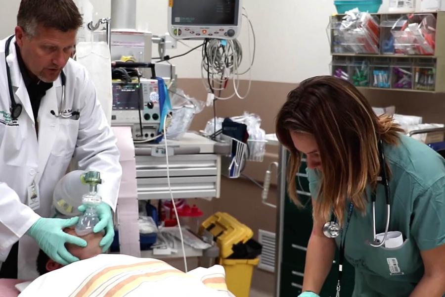 Two doctors working with a patient in an Emergency room.