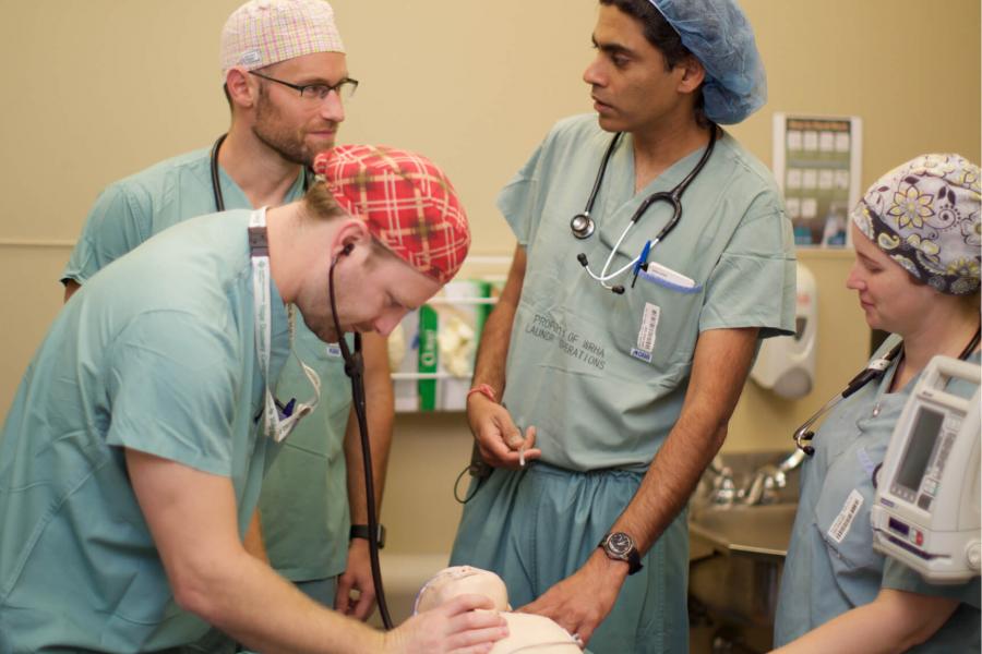 Pediatric anesthesia students perform an anesthesia simulation using a mannequin.