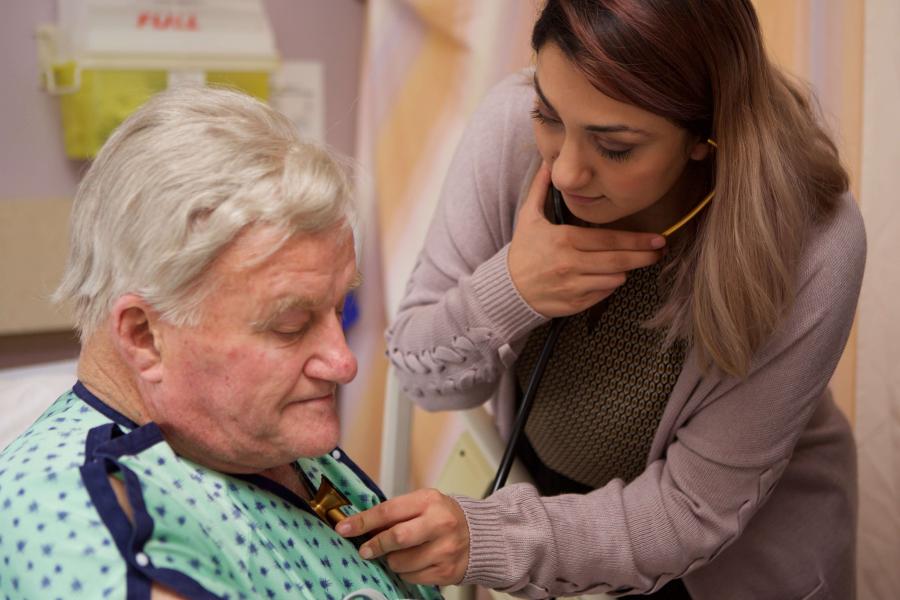 Physician listens to a patient's breathing with a stehoscope
