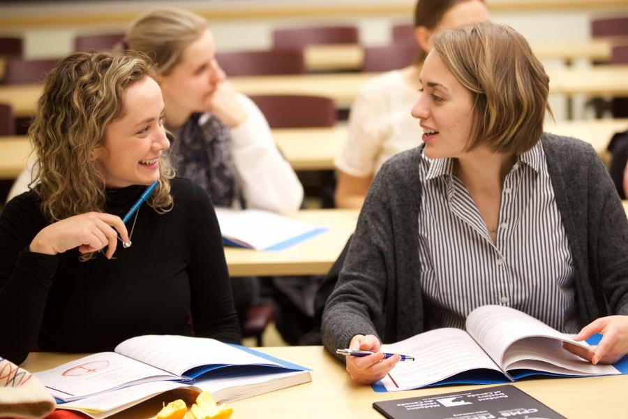 Students talking about an assignment in a classroom. 