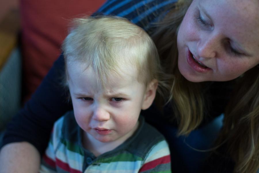 Unhappy child being comforted by his mother.