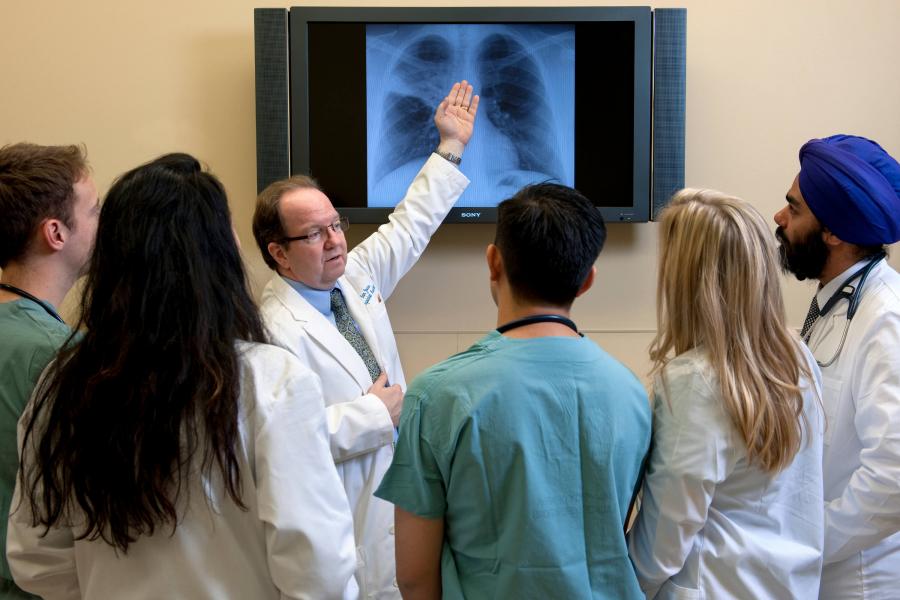 A physician explains an x-ray to a group of residents.