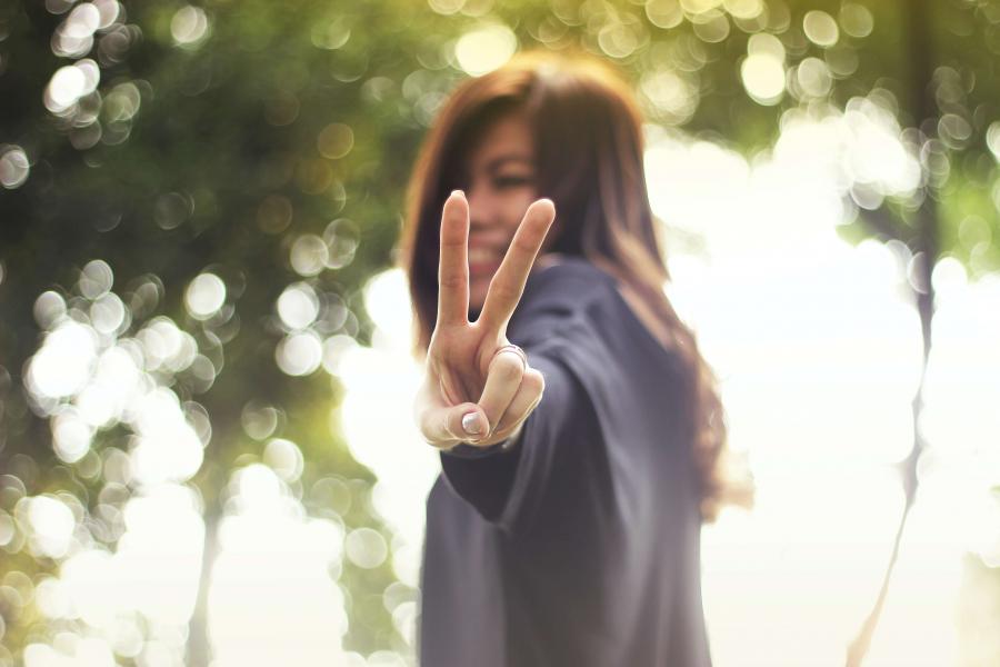 Young woman giving a peace sign.