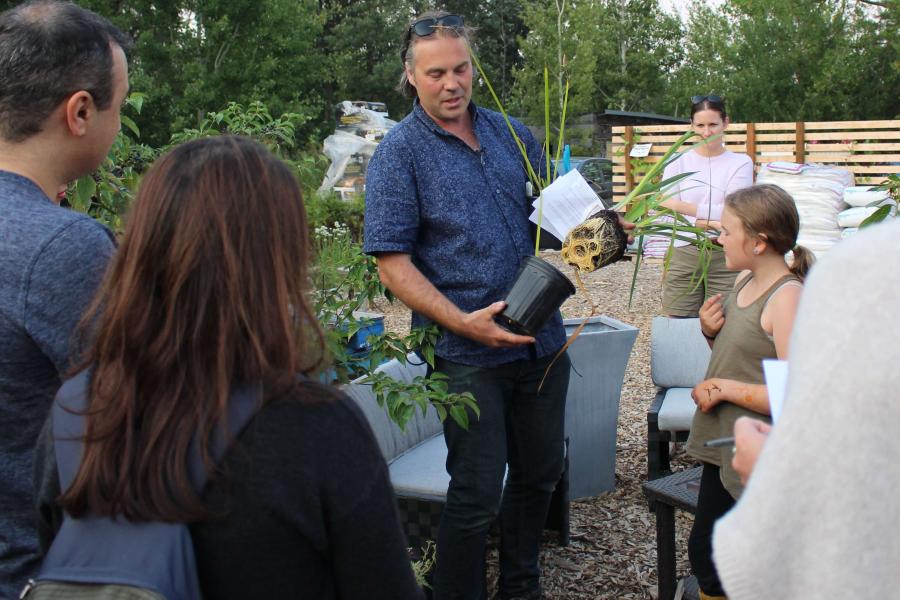 Man shows the roots of a medicinal plant to an audience