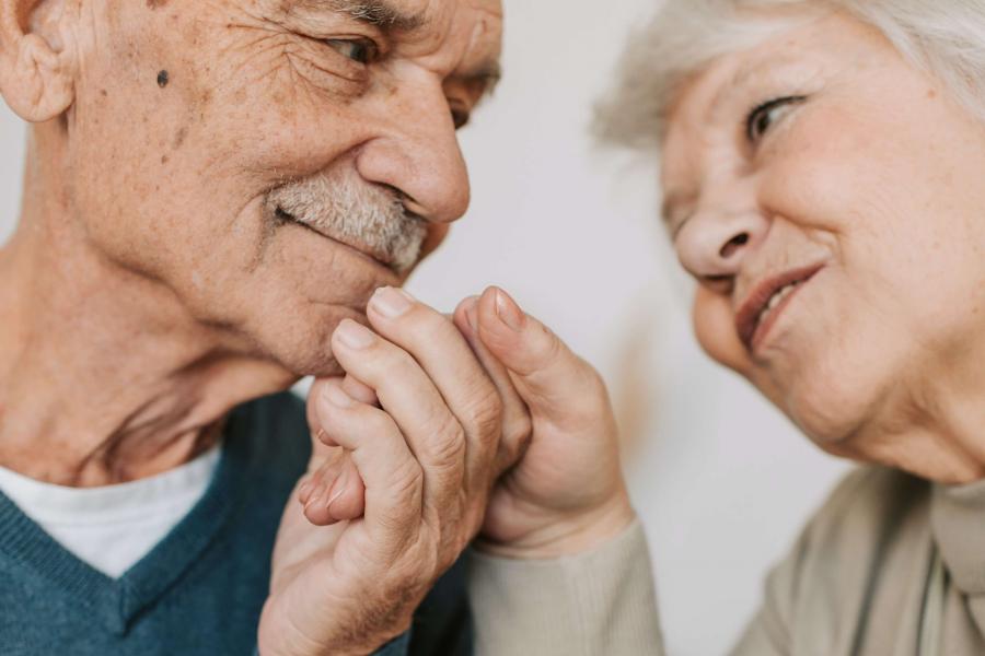 Elderly couple smiling at each other.