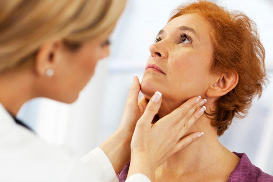 Woman receiving thyroid check.