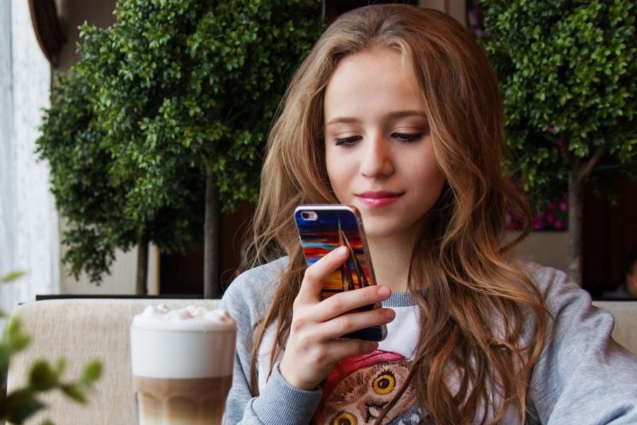 Teen girl looking at a cell phone.